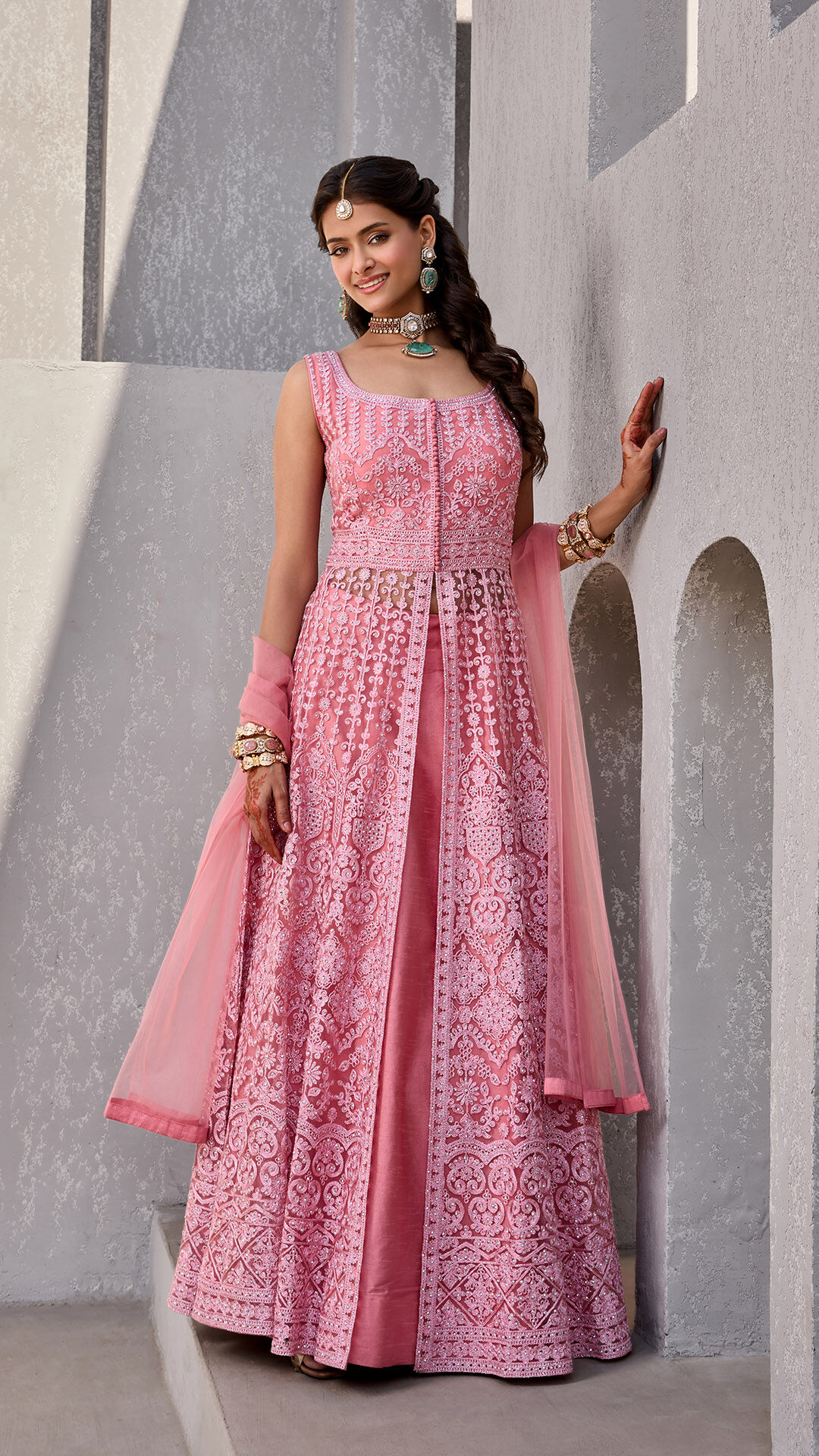 Woman wearing a vibrant pink Indian suit styled for a traditional celebration